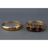 A yellow metal carved half hoop garnet and CZ ring, stamped '9' for 9ct,