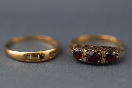 A yellow metal carved half hoop garnet and CZ ring, stamped '9' for 9ct,
