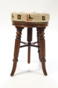A Victorian mahogany revolving piano stool with upholstered seat