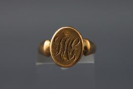 A yellow metal locket design signet ring with personal inscription.