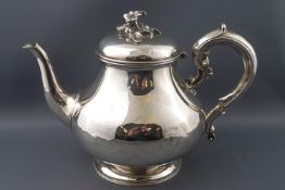 A Victorian pear shaped silver tea pot with applied scroll handle,