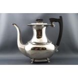 A silver coffee pot of rectangular baluster form raised on four paw feet,