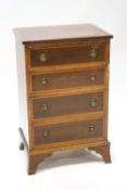 An Edwardian mahogany small chest of four drawers with satinwood cross banding on bracket feet,