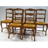 A set of six French chairs with shaped ladder backs on rush seats on cabriole legs joined by turned