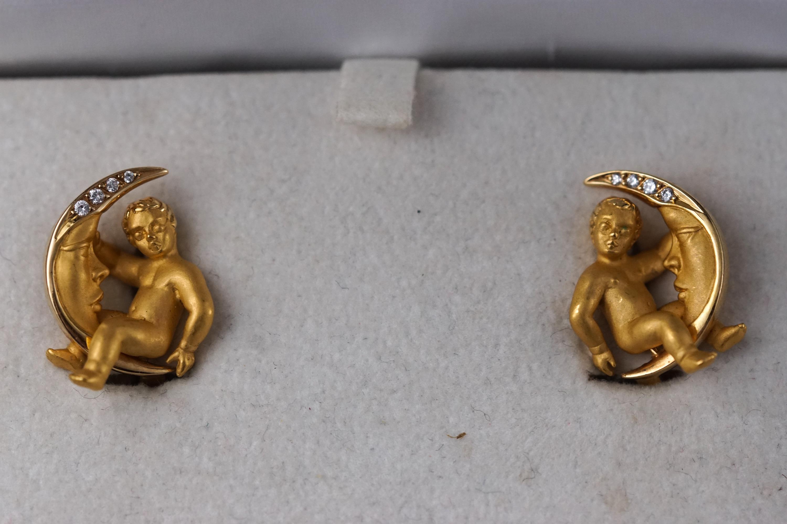 A yellow gold pair of Carrera Y Carrera earrings stylized as a cherub with a moon,