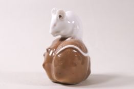 A Royal Copenhagen porcelain figure of a mouse upon a chestnut, shape 571, 6.