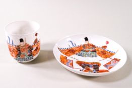 A Japanese porcelain saki cup and saucer, painted with warriors, six character marks,