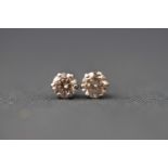 A white metal pair of single stone diamond stud earrings. stated 0.30ct total weight.