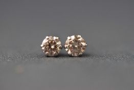 A white metal pair of single stone diamond stud earrings. stated 0.30ct total weight.