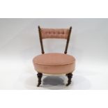 A Victorian walnut and pink upholstered nursing chair with ceramic casters