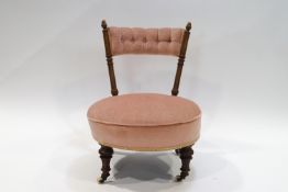 A Victorian walnut and pink upholstered nursing chair with ceramic casters