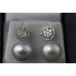 A white metal pair of South Sea pearl and diamond drop earrings.