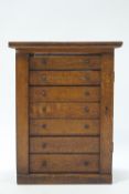 An early 20th century oak collector's cabinet of seven drawers,