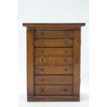 An early 20th century oak collector's cabinet of seven drawers,