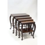A quartet of four 1930's Asian hardwood nest of tables with acanthus carved shoulders on claw and