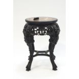 A Chinese carved hardwood table with inset marble top,