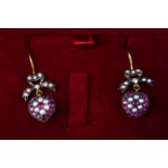 A 9ct and silver gilt pair of drop earrings each set with seed pearls, rubies and rose cut diamonds.