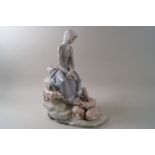 A Lladro porcelain figure of a girl seated on rocks with five piglets at her feet.