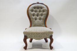 A Victorian walnut button back nursing chair with spoon back on cabriole legs