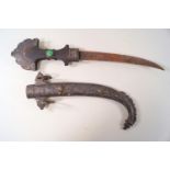 A Mugal dagger, with curved blade, the hilt set with a green disk, in mixed metal sheath,