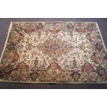 A Kerman Iranian handmade rug with flowers on a cream field within one wide border,