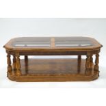 A glass topped walnut veneered coffee table, with eight legs,