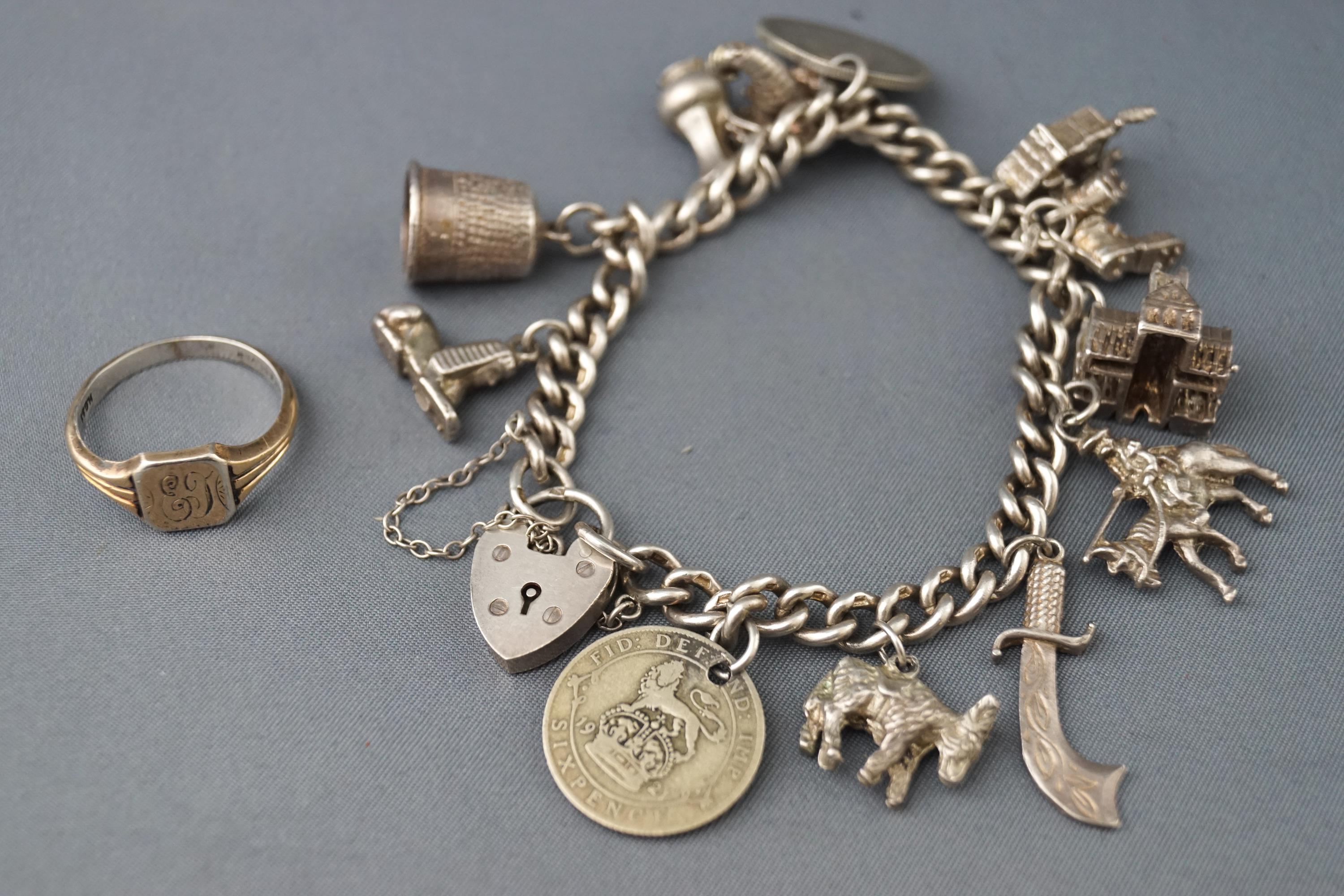 A sterling silver charm bracelet with assorted charms together with a 9ct on silver signet ring.