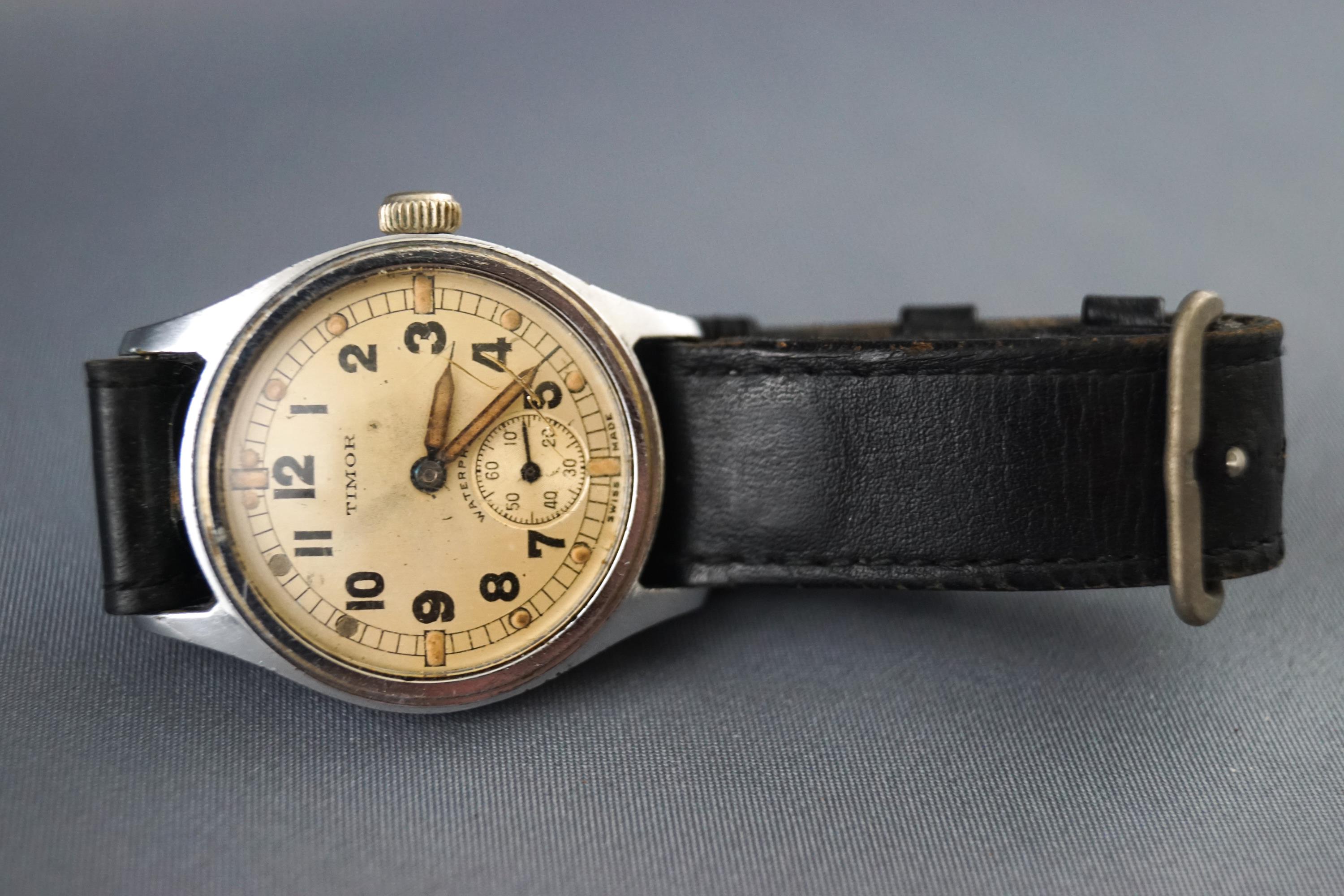 A WWII Timor military wrist watch with leather strap, engraved ATP.