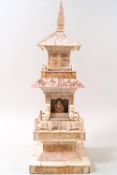 An early 20th century carved ivory temple with figure of a deity,