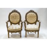 A pair of French elbow chairs each with carved frames and button backs,