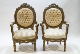 A pair of French elbow chairs each with carved frames and button backs,