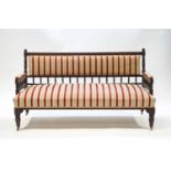 An Edwardian mahogany spindle back sofa with reed and floral striped upholstery