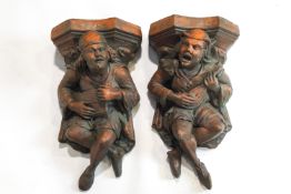 A pair of terracotta wall gargoyles, each playing a musical instrument,