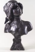 A bronze bust of a woman wearing a cap,