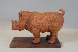 Ron Olley - A terracotta figure of a rhinocerous,