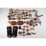 A collection of military cap badges, buttons,
