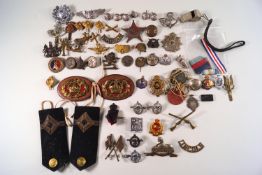 A collection of military cap badges, buttons,