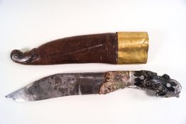 A Middle Eastern knife with carved handle and plated mounts and sheath