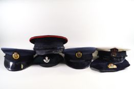 Six, various military caps, including Naval,