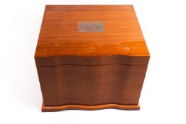 A bow fronted hardwood humidor with fitter interior and integral musical movement,