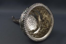 A highly decorated wine funnel, the bowl with repousse floral sprays and c scrolls, London 1818,