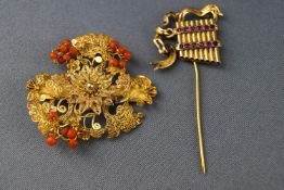 A yellow metal filigree floral brooch with coral beads together with a abstract section of brooch,