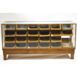 An oak and other hardwood and glazed Haberdashery cabinet, set with a multitude of drawers,