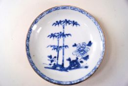 A Nanking cargo porcelain saucer, painted in underglaze blue with a peony and bamboo,