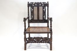 A Victorian carved elbow chair with caned seat and back, in 17th century style,