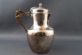 A white metal jug by Christofle, of baluster form with domed lid,