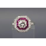 An 18ct white gold diamond and ruby art deco style target ring, centre diamond.