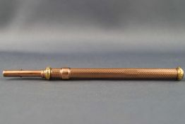 A rose and yellow coloured metal dual action propelling pencil and dip pen with engine turned