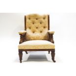 A Victorian armchair with deep buttoned upholstery, the arms on turned baluster supports,
