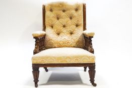 A Victorian armchair with deep buttoned upholstery, the arms on turned baluster supports,
